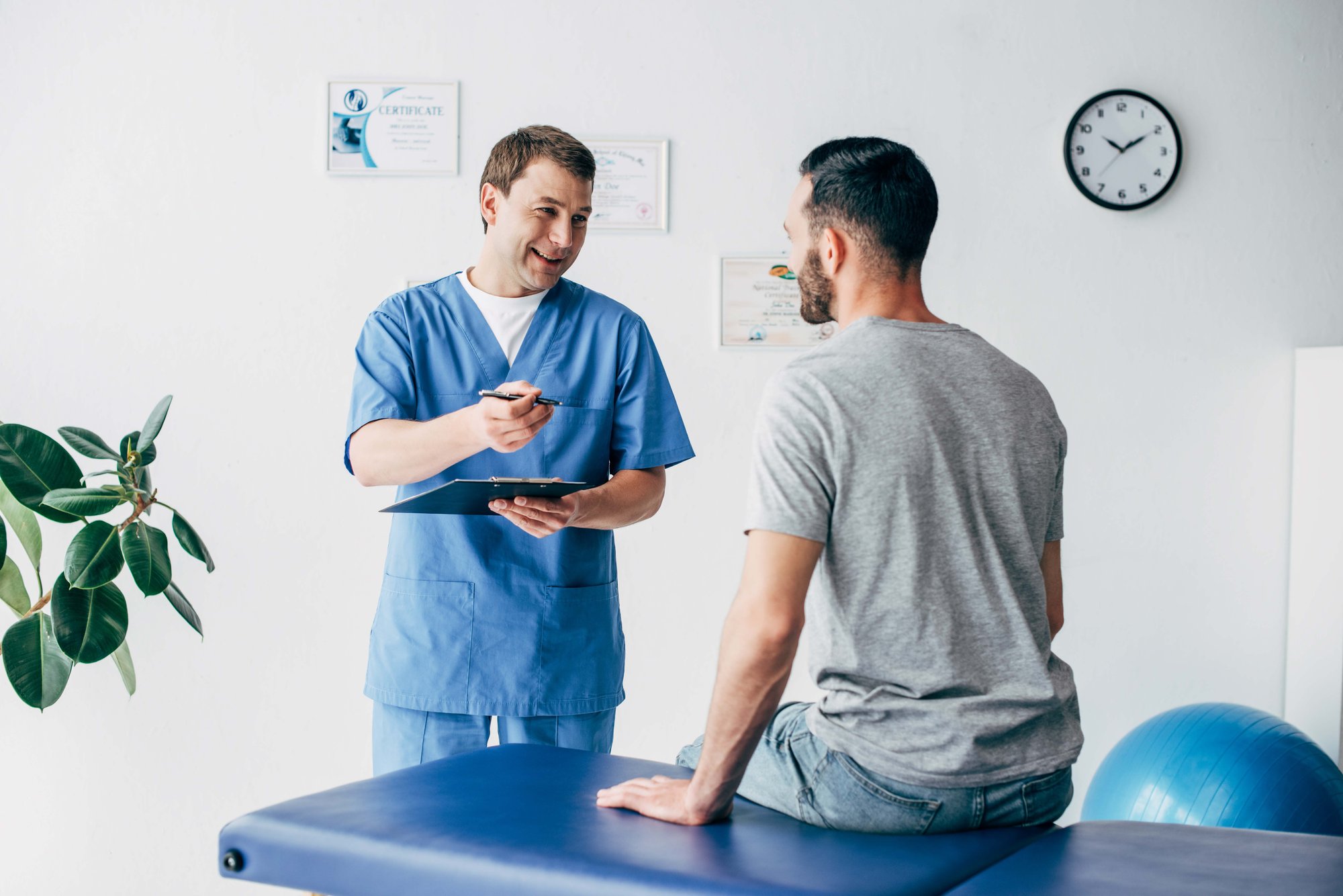 doctor explaining to patient while standing by an examination bed