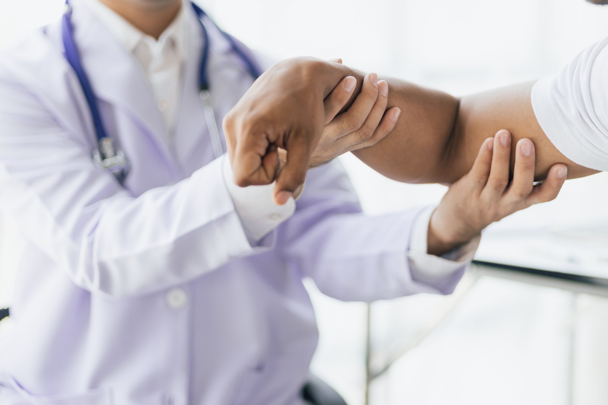 doctor holding patient's hand and arm