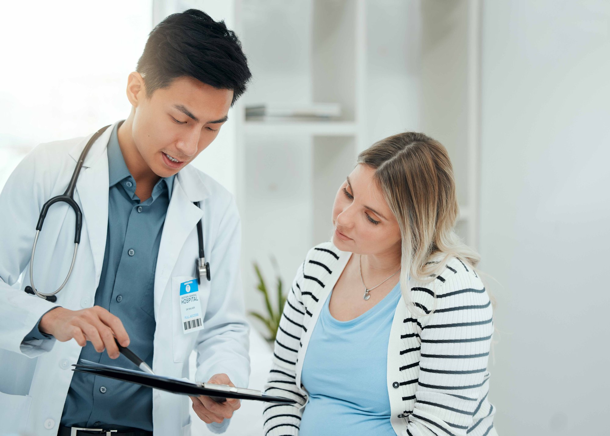 doctor showing maternity patient a tablet pointing with a pen